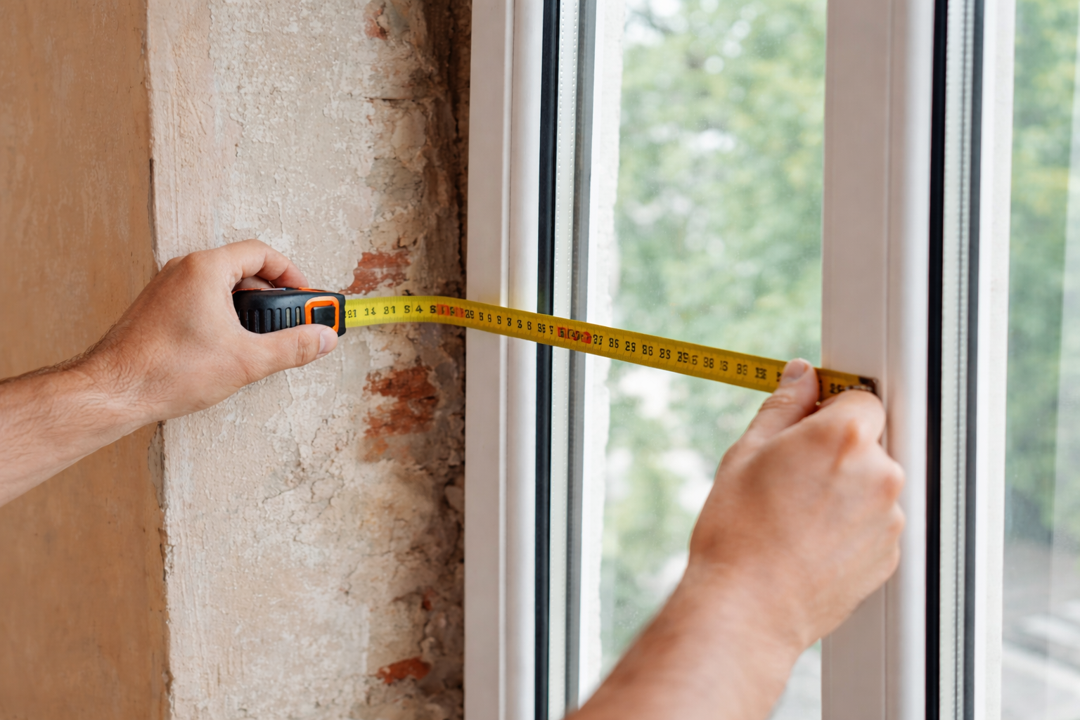 Замір віконного отвору рулеткою перед встановленням пластикових вікон